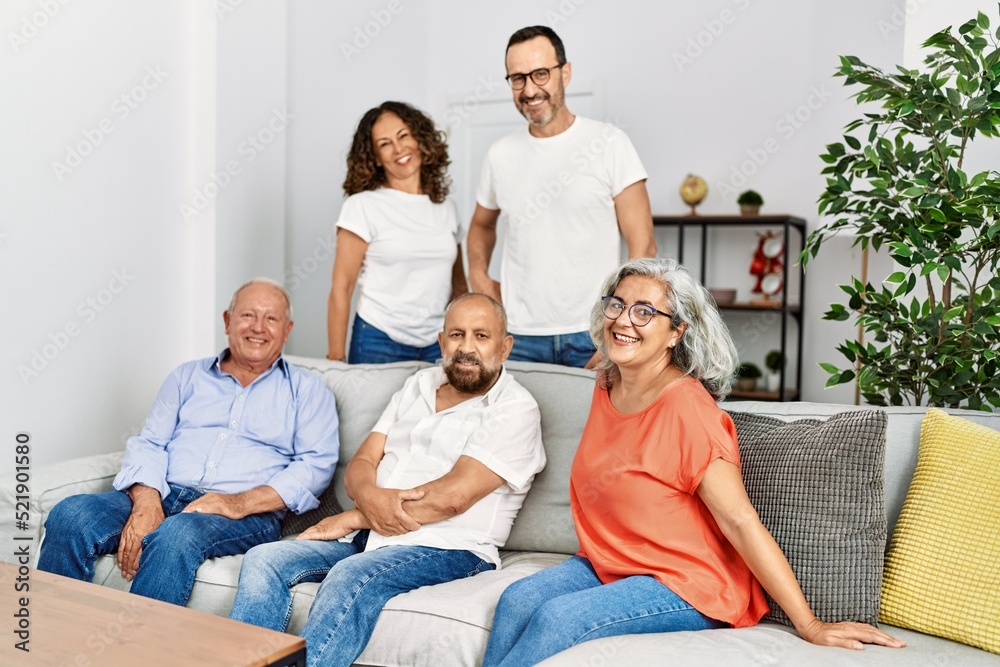Group of middle age friends smiling happy sitting on the sofa at home. Group of middle age friends smiling happy sitting on the sofa at home.