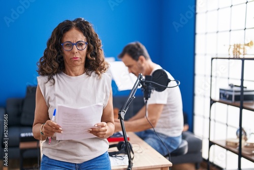 Middle age hispanic woman singing at music studio skeptic and nervous, frowning upset because of problem. negative person.