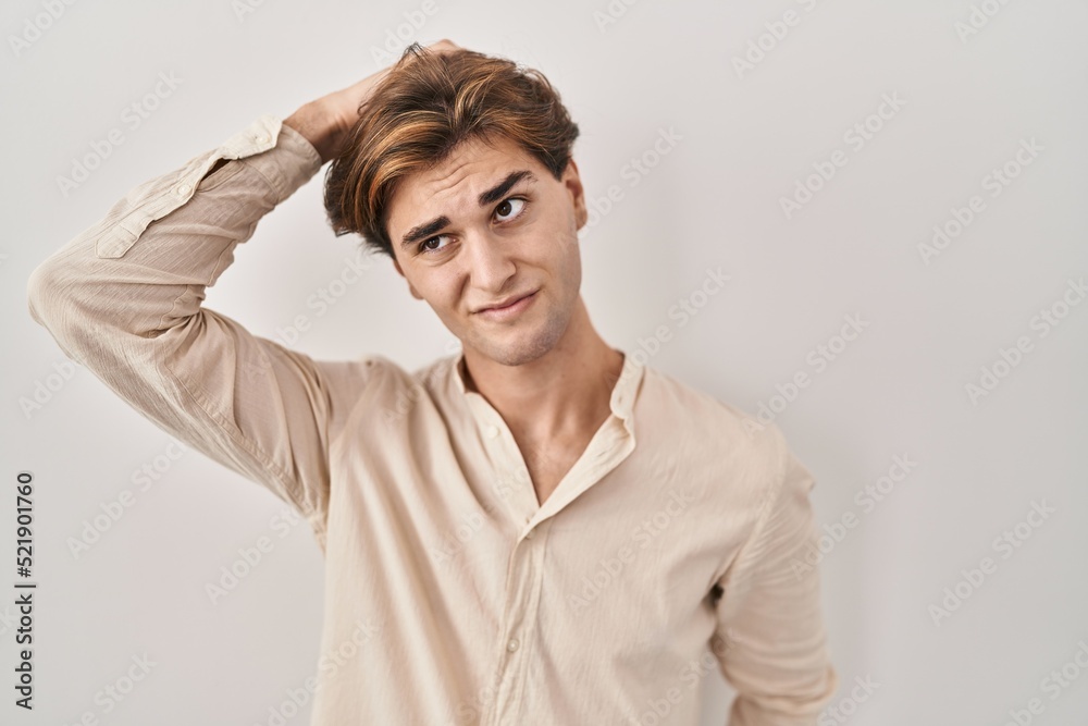 Young man standing over isolated background confuse and wondering about question. uncertain with doubt, thinking with hand on head. pensive concept. Young man standing over isolated background confuse and wondering about question. uncertain with doubt, thinking with hand on head. pensive concept.