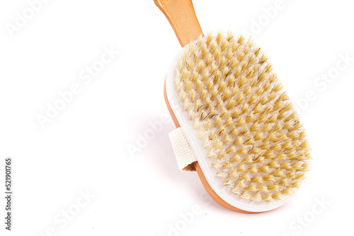 Natural shower brush with a wooden handle on a white background close-up.