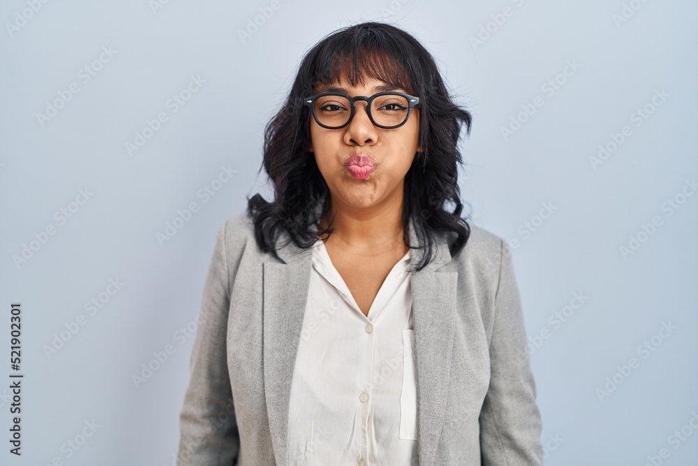 Hispanic woman standing over isolated background puffing cheeks with funny face. mouth inflated with air, crazy expression.