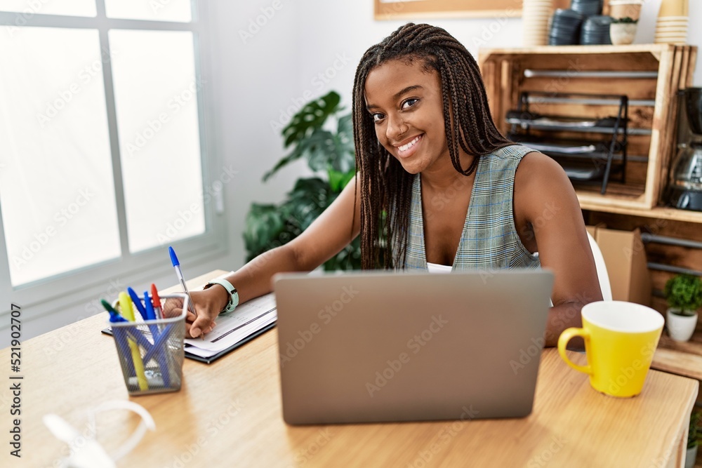 Young african american woman business worker writing on clipboard working at office