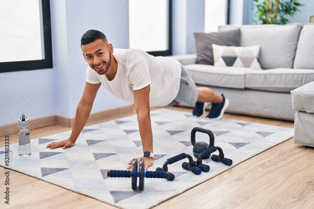 Fototapeta premium African american man smiling confident training abs exercise at home