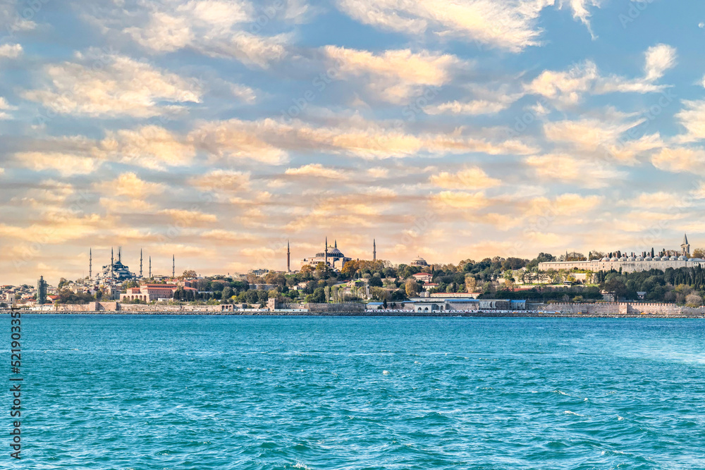 Istanbul cityscape from Bosphorus ferry with Hagia Sofia, Blue Mosque with sunset sky