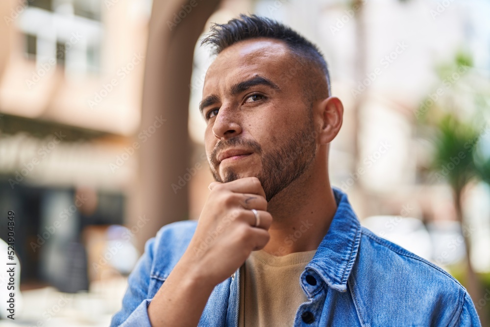 Young hispanic man standing with doubt expression at street Young hispanic man standing with doubt expression at street