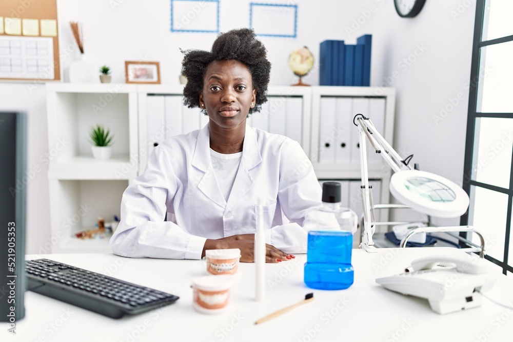 African dentist woman working at medical clinic with serious expression on face. simple and natural looking at the camera. African dentist woman working at medical clinic with serious expression on face. simple and natural looking at the camera.