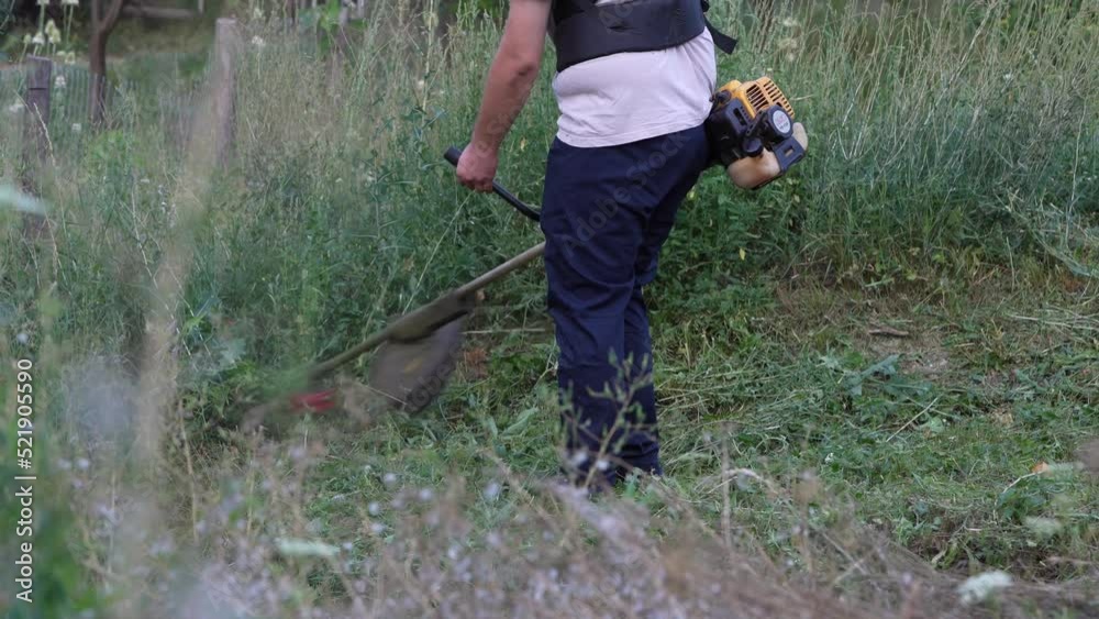 caucasian man farmer using string trimmer to cut grass brush cutter caucasian man farmer using string trimmer to cut grass brush cutter