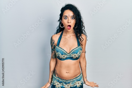 Young woman wearing bindi and traditional belly dance clothes afraid and shocked with surprise and amazed expression, fear and excited face.