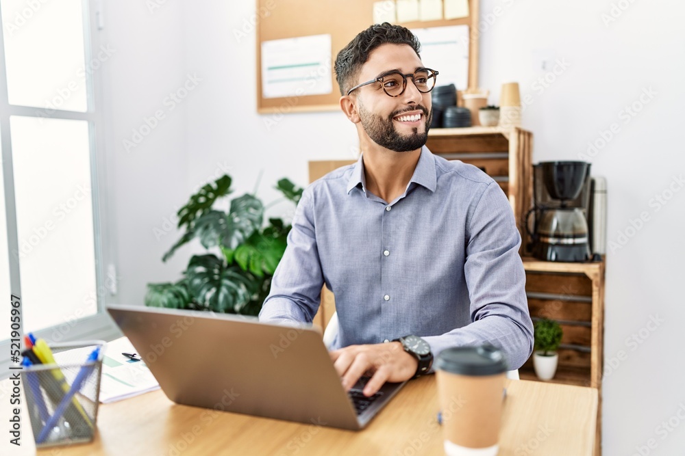 Young arab man smiling confident using laptop working at office Young arab man smiling confident using laptop working at office
