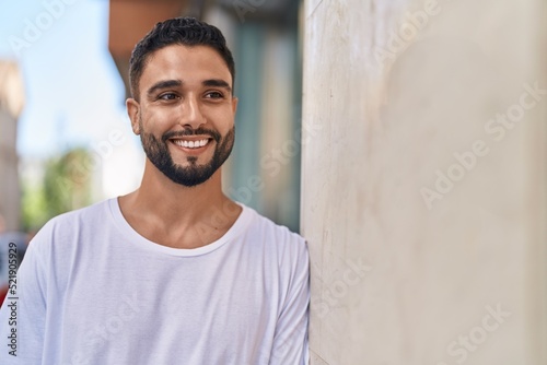 Young arab man smiling confident looking to the side at street