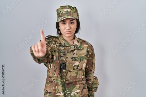 Young south asian woman wearing camouflage army uniform pointing with finger up and angry expression, showing no gesture