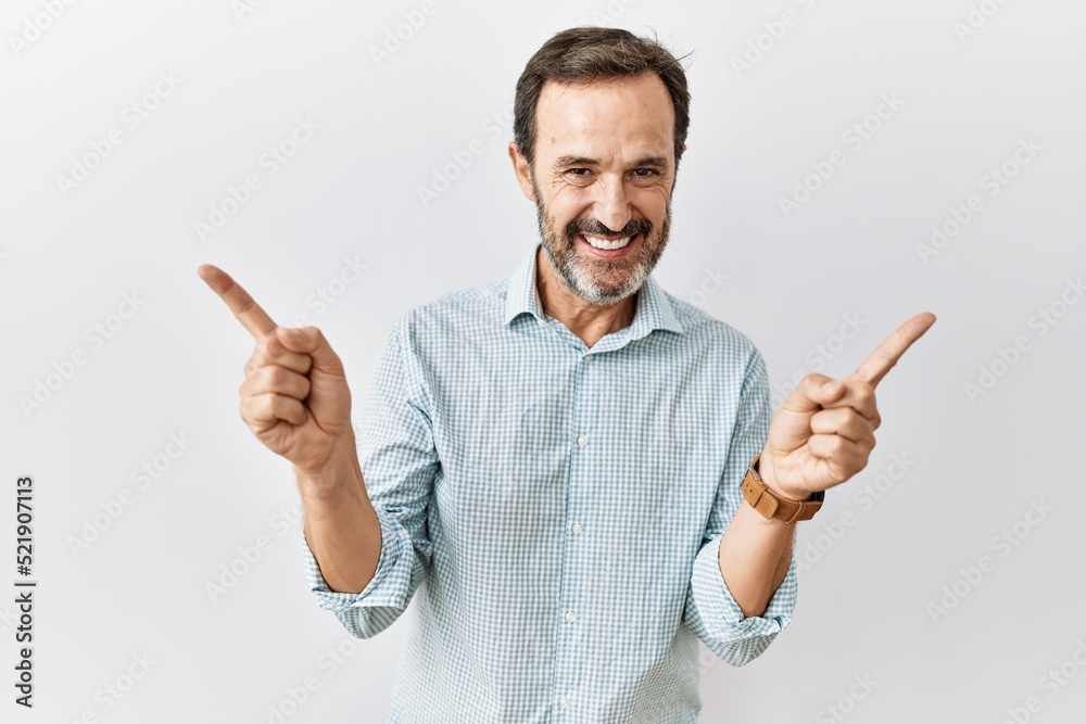 Middle age hispanic man with beard standing over isolated background smiling confident pointing with fingers to different directions. copy space for advertisement Middle age hispanic man with beard standing over isolated background smiling confident pointing with fingers to different directions. copy space for advertisement