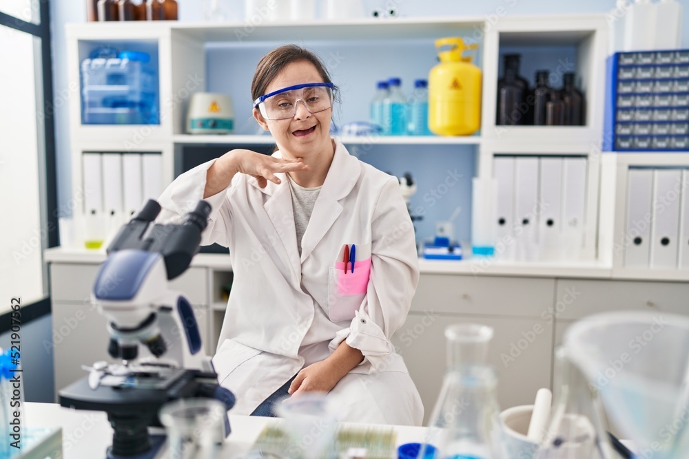 Hispanic girl with down syndrome working at scientist laboratory cutting throat with hand as knife, threaten aggression with furious violence Hispanic girl with down syndrome working at scientist laboratory cutting throat with hand as knife, threaten aggression with furious violence