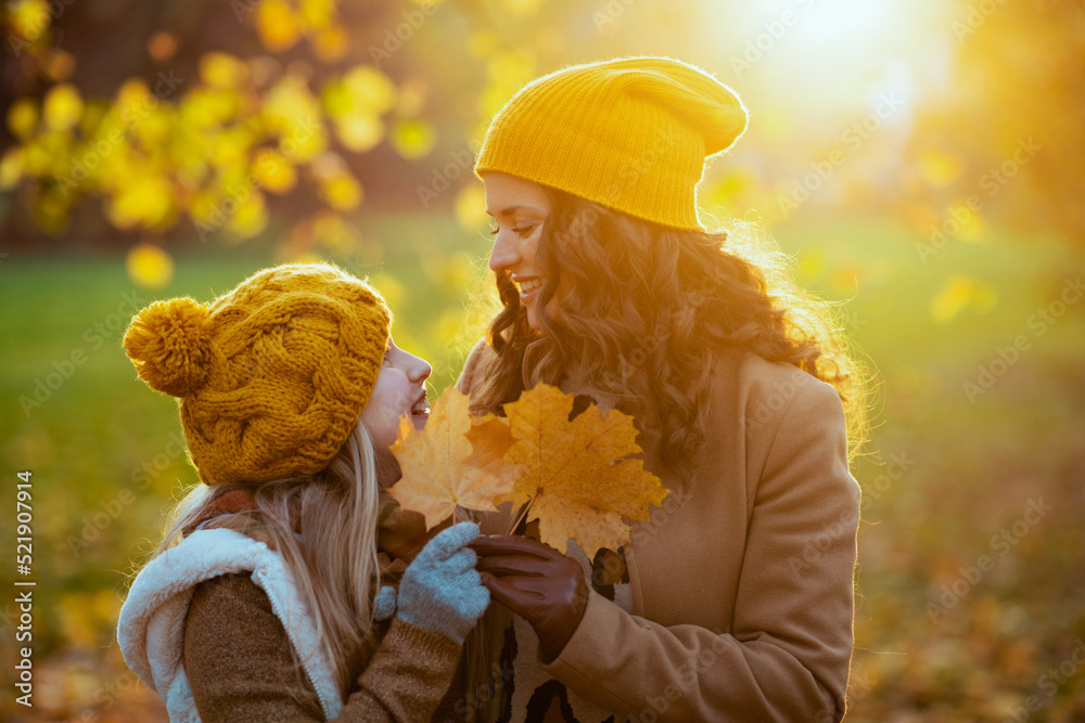 smiling modern mother and child outside in city park in autumn Stock ...