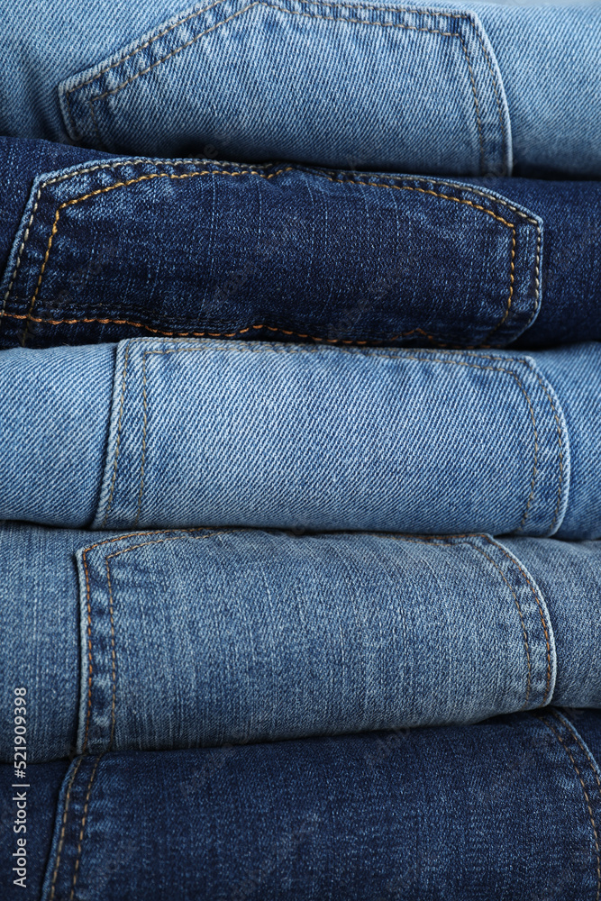 Stack of different jeans as background, closeup Stack of different jeans as background, closeup