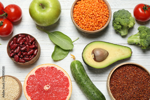 Different vegetables, seeds and fruits on white wooden table, flat lay. Healthy diet photo