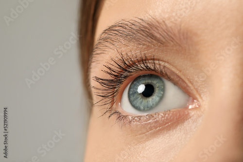 Beautiful woman with grey eyes on color background, closeup