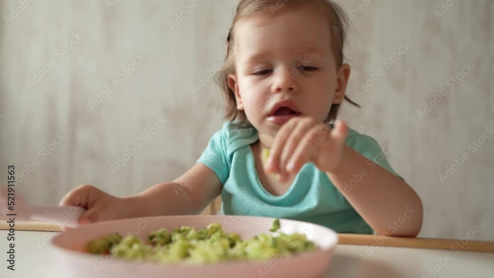 one girl small caucasian child one year old eat at the table at home one girl small caucasian child one year old eat at the table at home