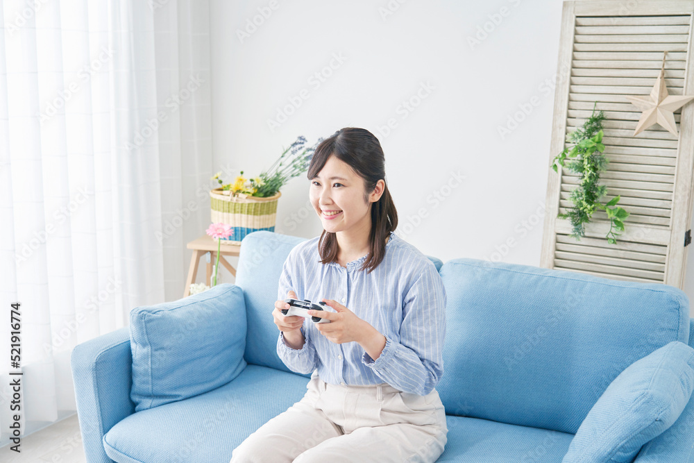 自宅で一人でテレビゲームをする女性 自宅で一人でテレビゲームをする女性
