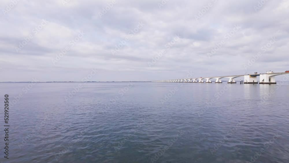 drone flight over the bank of the eastern scheldt in the netherlands over water towards the huge zeeland bridge with passing traffic drone flight over the bank of the eastern scheldt in the netherlands over water towards the huge zeeland bridge with passing traffic