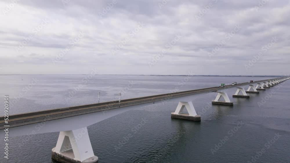 drone flight passing the zeeland bridge over the eastern scheldt with oncoming traffic up the road drone flight passing the zeeland bridge over the eastern scheldt with oncoming traffic up the road