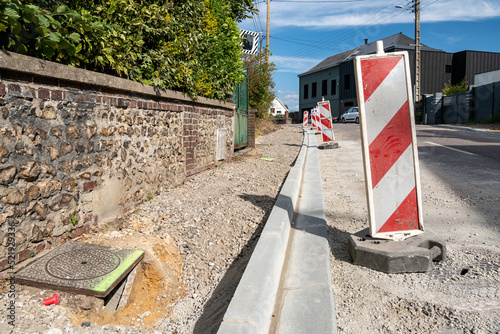 Réfection de trottoir et caniveau dans une rue. Pose de bordures en ciment photo