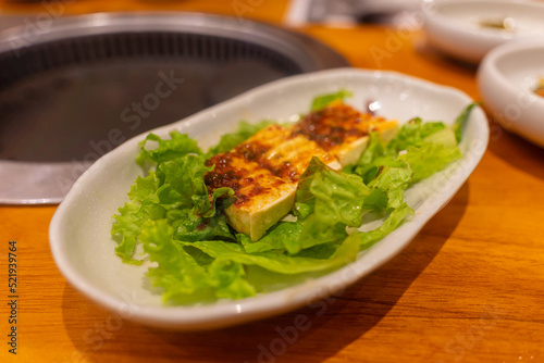 Tofu with Korean spicy soy and sesame oil sauce, salad. Food and travel concept. Close focus