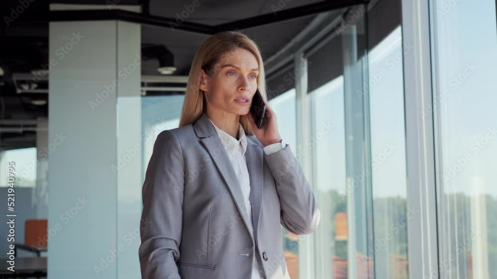 Successful company female leader. Serious businesswoman talking mobile phone in office. Confident manager CEO portrait having smartphone conversation indoor. Business lady woman solves the tasks. Successful company female leader. Serious businesswoman talking mobile phone in office. Confident manager CEO portrait having smartphone conversation indoor. Business lady woman solves the tasks.