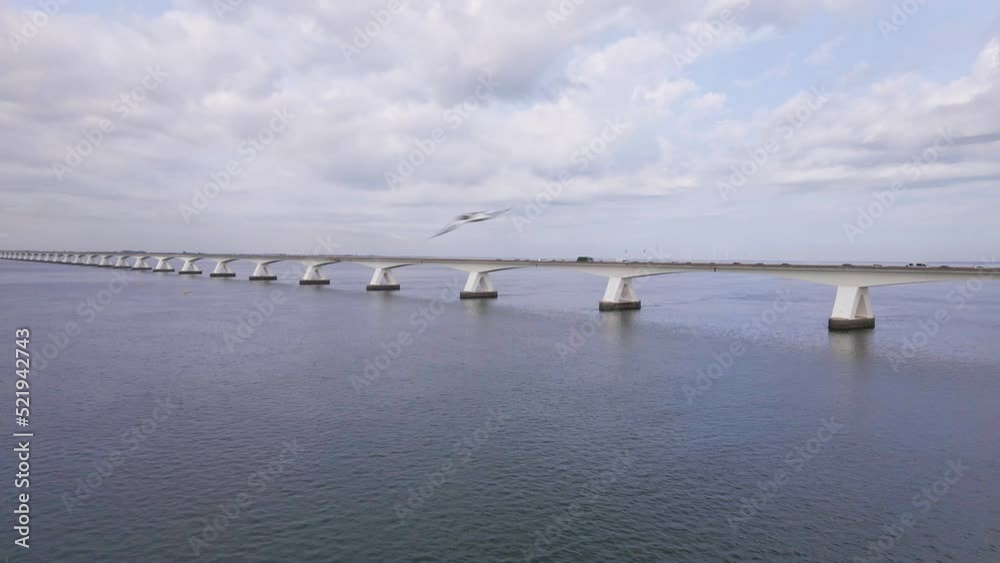 beautiful drone flight over the water from the eastern schelde to the Zeeland bridge under a cloudy sky beautiful drone flight over the water from the eastern schelde to the Zeeland bridge under a cloudy sky