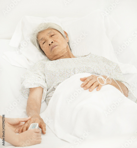 Close-up of blood oxygen oximeter and heart rate from a elderly patient fingertip in room at the hospital. Health care concept photo