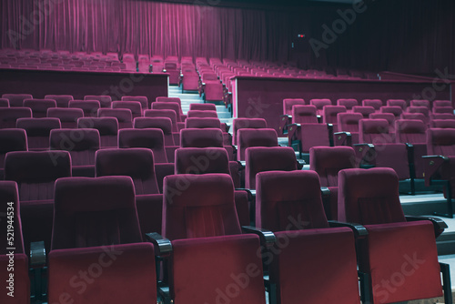 Empty red chairs for audience in the theater