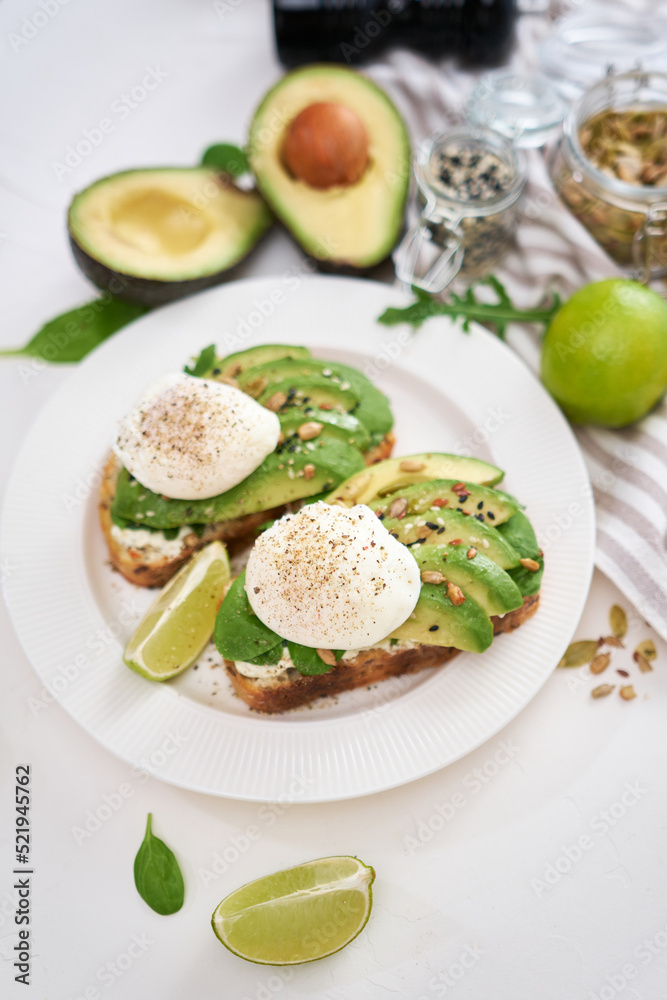 Freshly made poached egg and Avocado toasts on light grey background