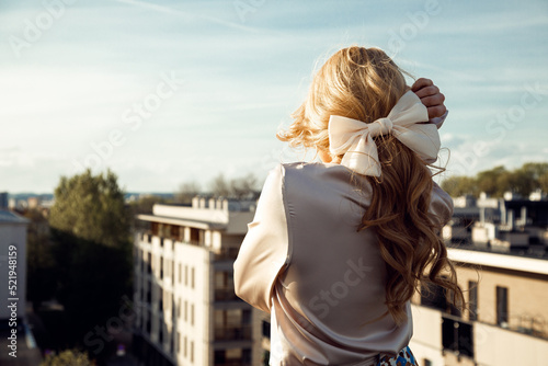 Photography Pretty girl in romantic outfit with wonderful hairstyle and big elegant bow standing back and looking around from observation platform closeup