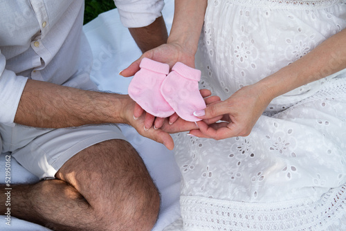 Pink socks for a newborn in the hands of a man and a woman
