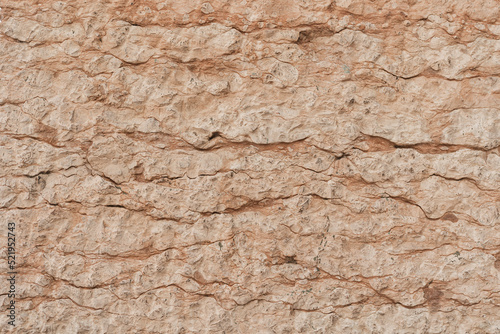 Texture of cracked beige stone rock wall. Old building. Neutral pastel colour background © Floral Deco