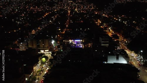 Aerial night view of a neighborhood in Medellin Colombia flying backwards photo