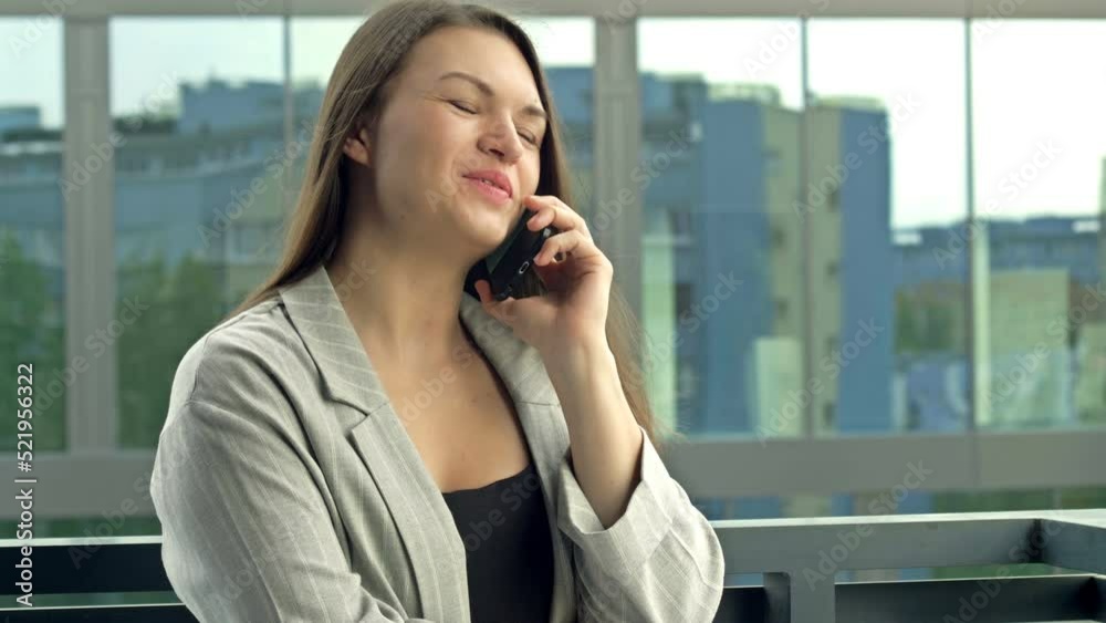 Beautiful young woman talking on the phone while standing on a city street. Beautiful young woman talking on the phone while standing on a city street.