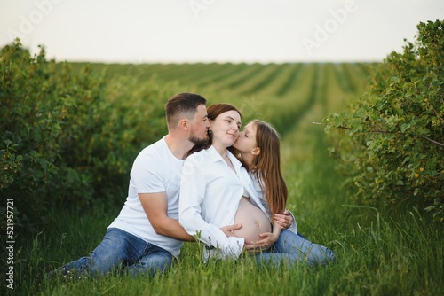 Pregnant woman with her family looking happy © Serhii