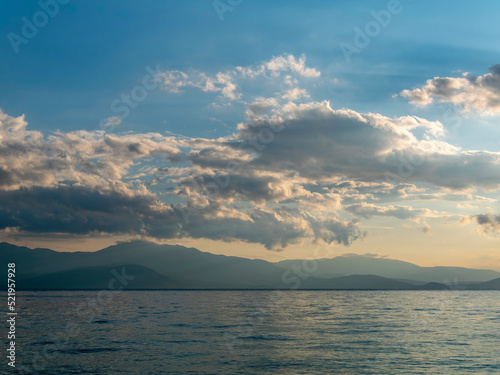 Cloudy sky above the sea and mountains in the background of the horizon. The change of weather is continuous in all seasons.