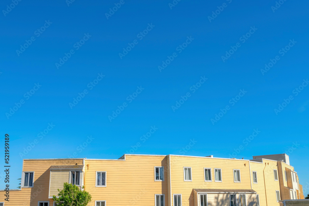Apartment building with yellow wood siding and casement windows in San Francisco, CA Apartment building with yellow wood siding and casement windows in San Francisco, CA