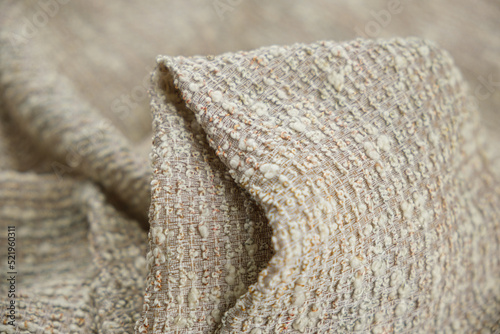 Close-up of textured wool fabric light brown colour with milk colour thread
