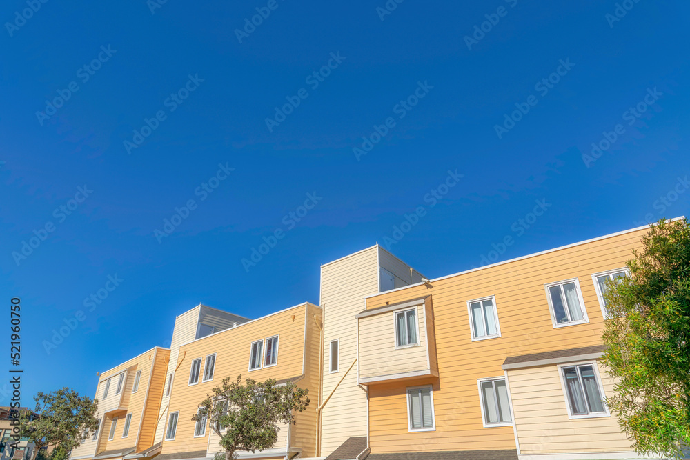 Exterior of an apartment building with beige and yellow wood lap siding in San Francisco, California