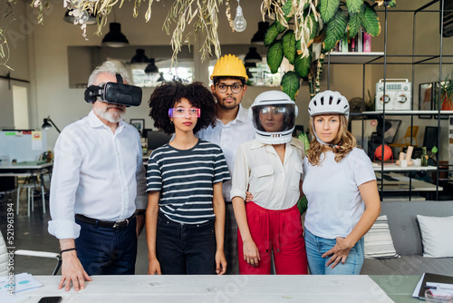 Multiracial business colleagues wearing different glasses and helmets in office photo