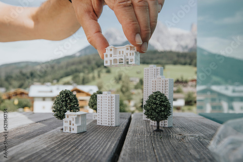 Hand of engineer positioning model home on table