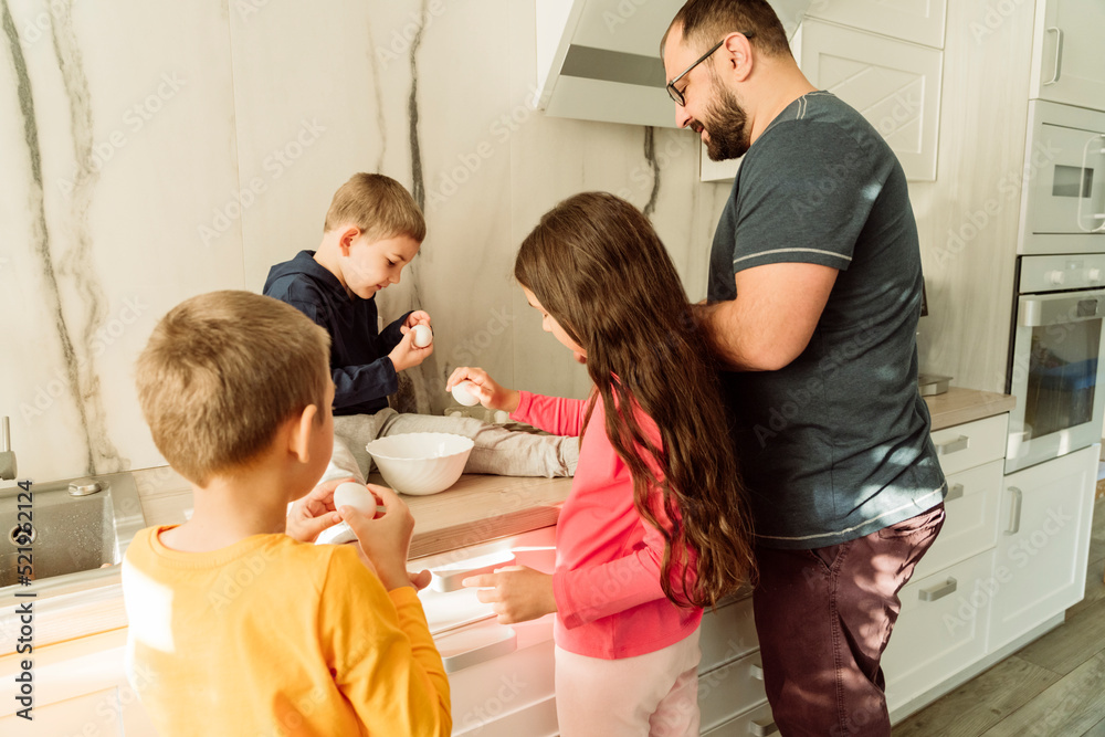 Man with children preparing breakfast in kitchen Man with children preparing breakfast in kitchen