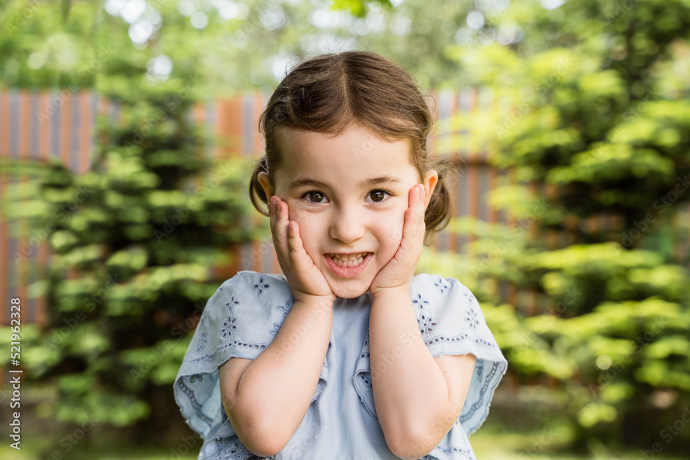 Cute girl standing with head in hands at back yard Cute girl standing with head in hands at back yard