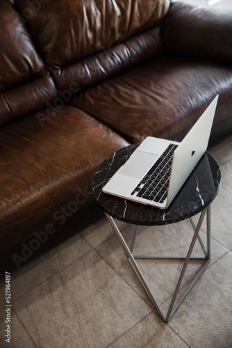 An open laptop on a coffee table. Work remotely or in the office, freelancing or remote work concept