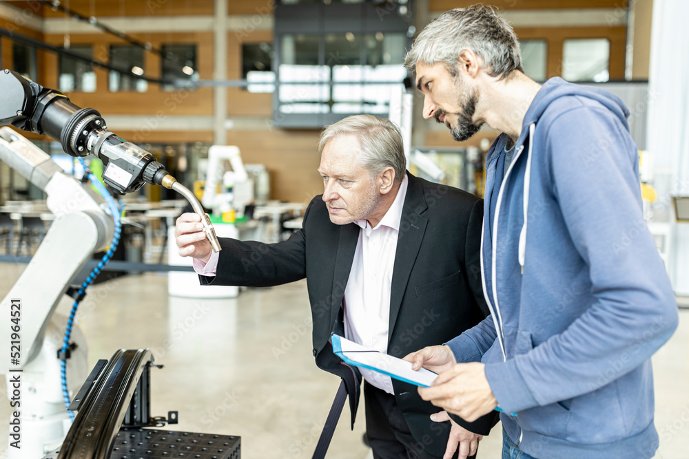 Senior customer getting advise on industrial robot from expert staff Senior customer getting advise on industrial robot from expert staff