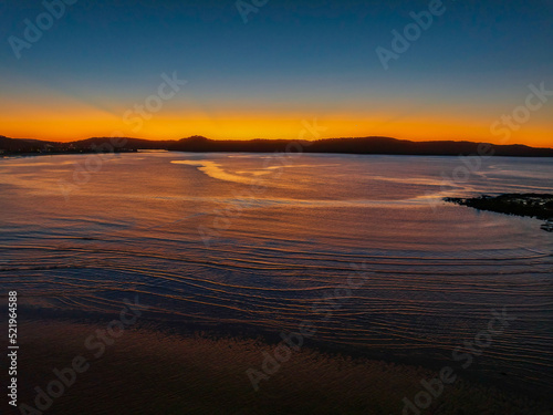 Aerial sunrise seascape with orange glow on a cold Winter s morning