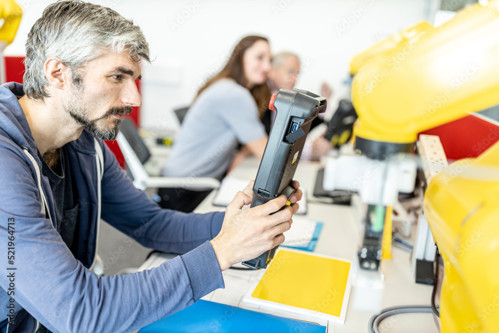 Industrial engineer working at robot arm using digital control